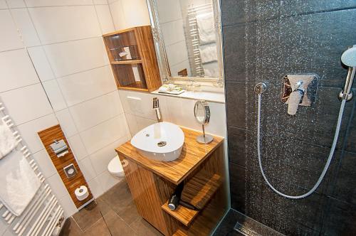 a bathroom with a sink and a shower at Hotel Allegro in Cologne