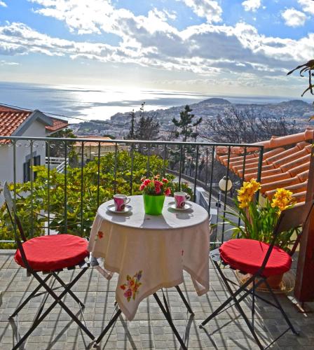 a table and chairs on a balcony with a view at Bela Vista in Funchal
