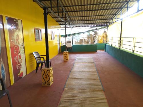 a room with a wooden floor and a yellow wall at Swastik Ac Apartment in Mandrem