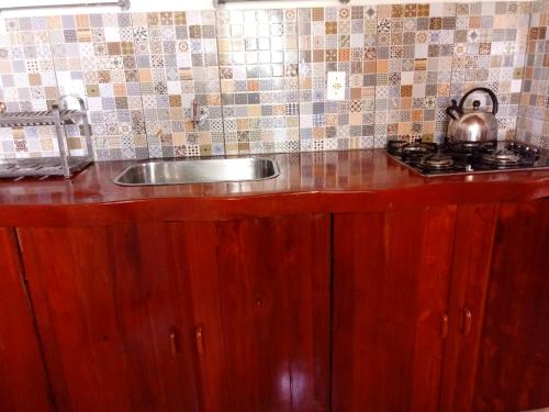 eine Küchentheke mit einer Spüle und einem Herd in der Unterkunft Bangalô Menotti in Prado