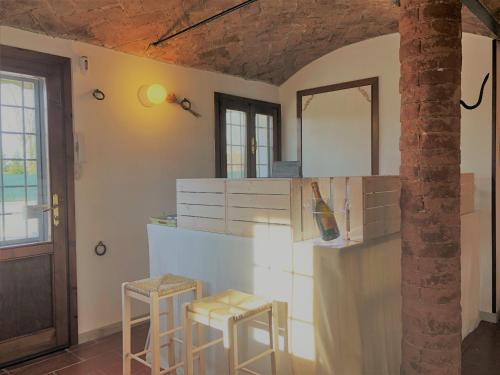a kitchen with two stools and a counter with a mirror at Il Contado -room and breakfast- in Castelfranco Emilia
