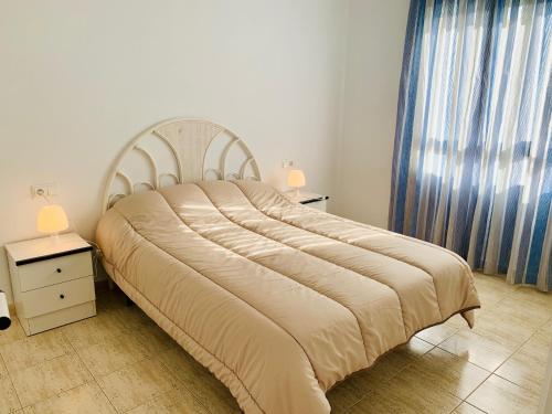 a large bed in a bedroom with two night stands at A531 - Calasol - 2004 Finestrat s.l. in Cala de Finestrat