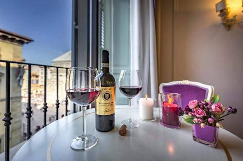 a bottle of wine and two glasses on a table at B&B La Terrazza Sul Duomo in Florence