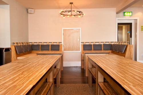 an empty synagogue with wooden benches and a chandelier at YHA Ambleside in Ambleside