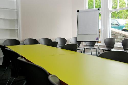 a conference room with tables and chairs and a screen at YHA Ambleside in Ambleside