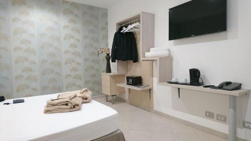 a room with a white counter and a tv on a wall at Hotel Centrale in Siracusa