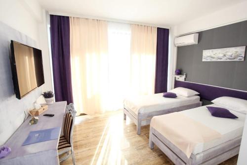 Cette chambre comprend deux lits et un bureau. dans l'établissement Lavender Villa, à Mamaia Nord – Năvodari