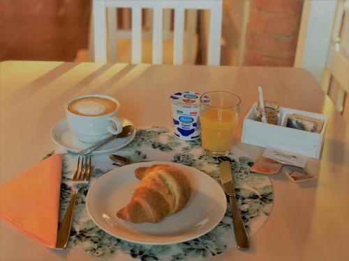 a table with a plate of bread and a cup of coffee at Il Contado -room and breakfast- in Castelfranco Emilia