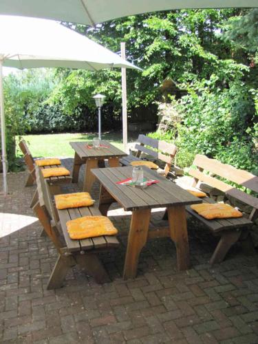 a wooden picnic table and chairs with an umbrella at "Unter den Kastanien" in Speicher