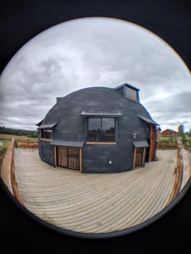 a large black house with a wooden boardwalk around it at Domos Eva-Ray in Panguipulli