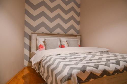 a bedroom with a bed with a striped wall at Grand Hills Zlatibor in Zlatibor