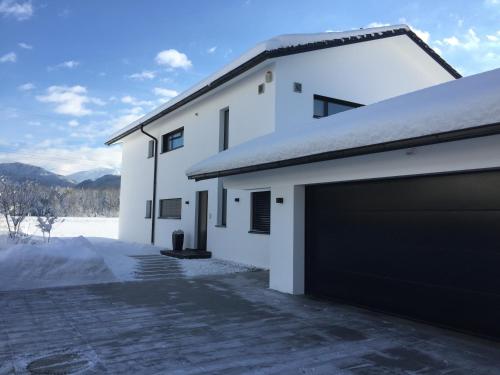 a white house with a garage at Ferienwohnung Black White in Raubling