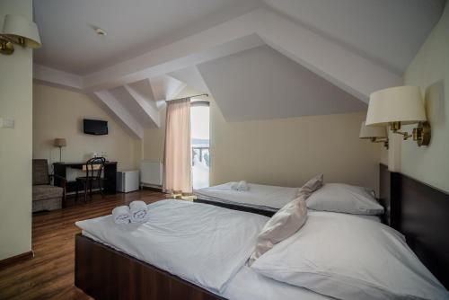 a bedroom with two beds with towels on them at Pensjonat pod Samowarem in Tylicz