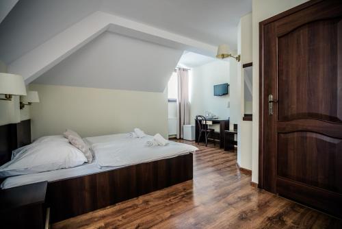 a bedroom with a bed and a wooden door at Pensjonat pod Samowarem in Tylicz