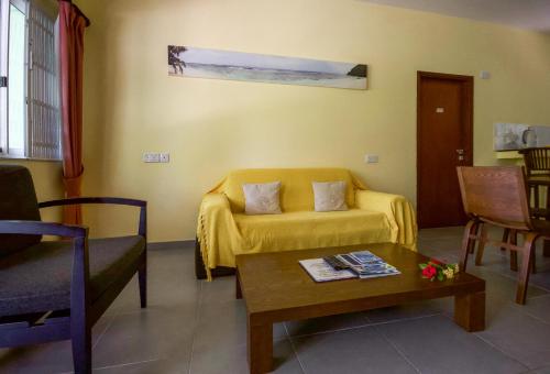 a living room with a couch and a coffee table at Surfers Beach Self Catering Chalets in Takamaka