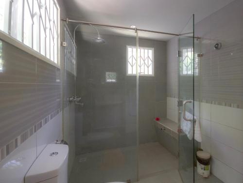 a bathroom with a glass shower and a toilet at Surfers Beach Self Catering Chalets in Takamaka