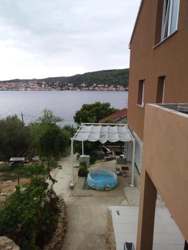 a view of a building with a tent and a pool at Apartment Pilatus Ošljak in Preko