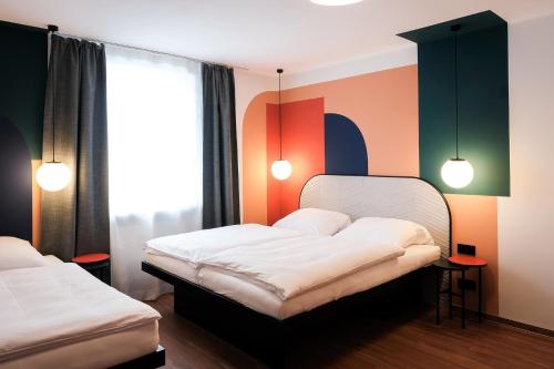 1 dormitorio con 2 camas y 2 lámparas en The Dot | 24/7 Checkin en Múnich