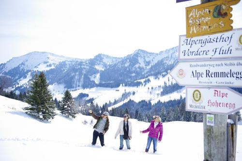 a group of three people walking in the snow at Hotel Tyrol - Oberstaufen PLUS Partner in Oberstaufen