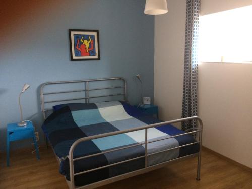 a bedroom with a bed with a blue wall at GÎTE Les Buis in Bussière-Portevine
