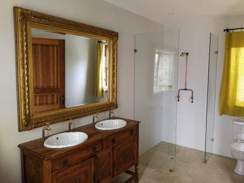 a bathroom with two sinks and a mirror at Bakovenbay Luxury Suites in Cape Town