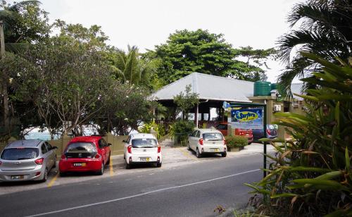 a group of cars parked on the side of a street at Surfers Beach Self Catering Chalets in Takamaka