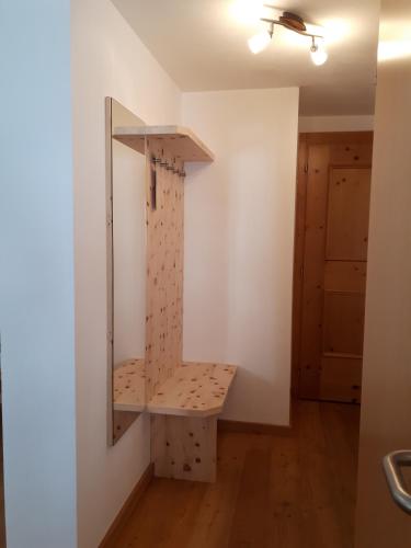 a room with a mirror and a bench on a wall at Landhaus Taurer in Kals am Großglockner