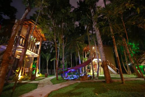 a resort with a slide in the woods at night at Limecabanas-srilanka in Galle