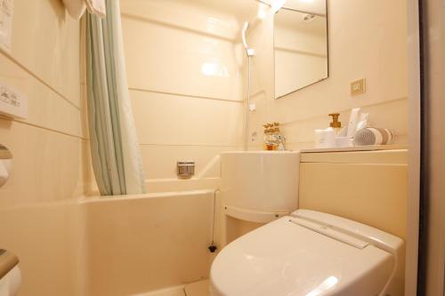 a bathroom with a toilet and a sink and a mirror at Shin-Osaka Sunny Stone Hotel in Osaka