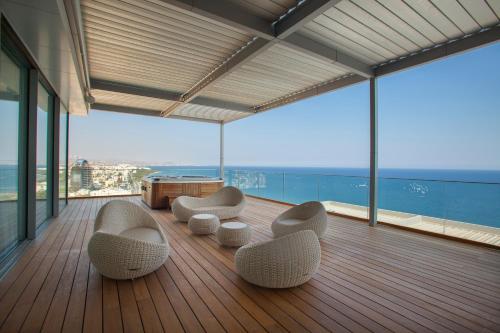 a room with chairs and tables on a wooden deck at Olympic Residence Deluxe Apartments in Limassol