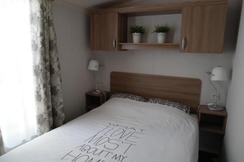 En eller flere senge i et værelse på Camping Parcvalrose Mobile Home No 79