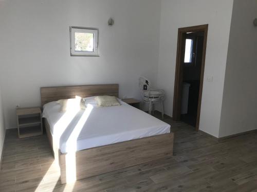 a bedroom with a bed with white sheets and a window at Apartments Sanja in Jezera