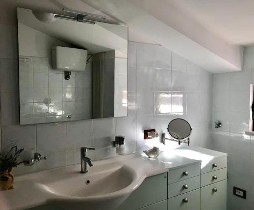 een witte badkamer met een wastafel en een spiegel bij Stella maris holiday house in Sorrento