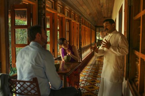 two men standing on a train talking to one another at Chittoor Kottaram Royal Mansion - A CGH Earth SAHA Experience in Cochin