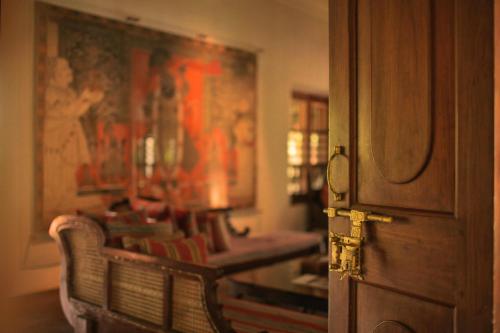 a room with two benches and a painting on the wall at Chittoor Kottaram Royal Mansion - A CGH Earth SAHA Experience in Cochin