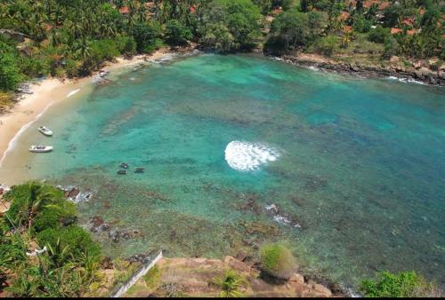 an aerial view of a beach with boats in the water at Light house beach home in Matara