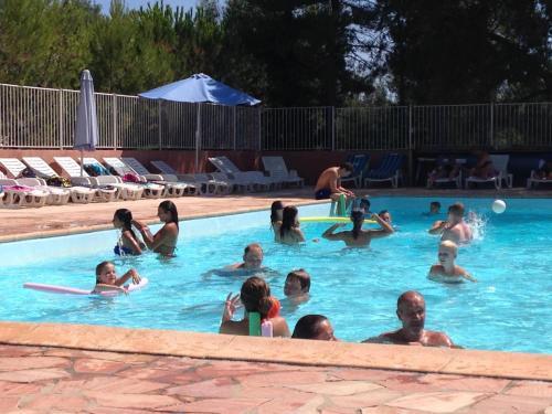 um grupo de pessoas numa piscina em Camping Parcvalrose Mobile Home No 79 em La Londe-les-Maures