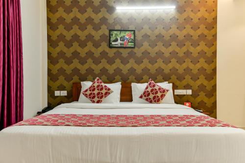 a bedroom with a large bed with red pillows at Hotel Hilite Inn in Cochin
