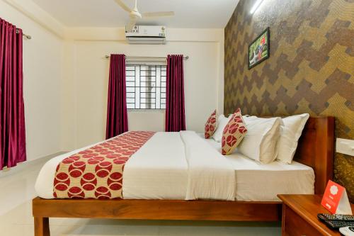 a bedroom with a large bed with red curtains at Hotel Hilite Inn in Cochin