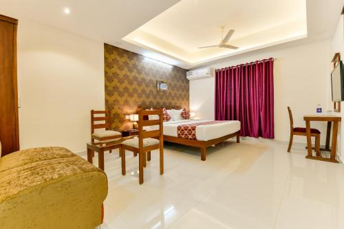 a hotel room with a bed and a table and chairs at Hotel Hilite Inn in Cochin