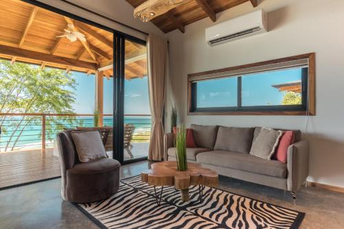 a living room with a couch and a chair at Vista del Alma Boutique - Adult Only in Santa Teresa Beach