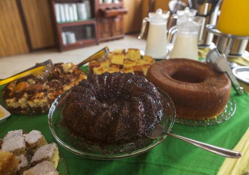 a table topped with different types of cakes and pastries at Lonier Ilha Inn Flats in Abraão