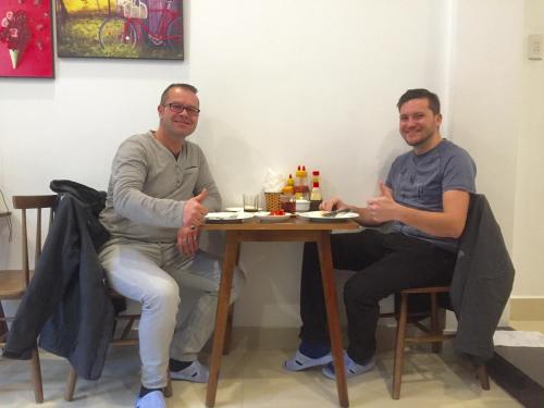 two men sitting at a table in a room at candyinn in Hue