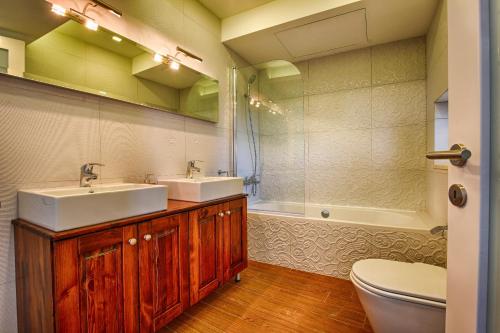 a bathroom with two sinks and a toilet and a tub at Aldo House in Għarb