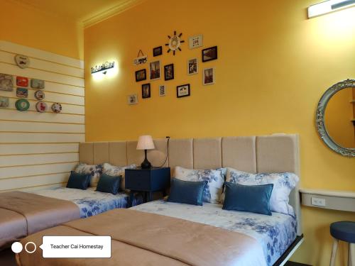 a bedroom with two beds and a mirror at Teacher Cai Homeestay in Xiaoliuqiu