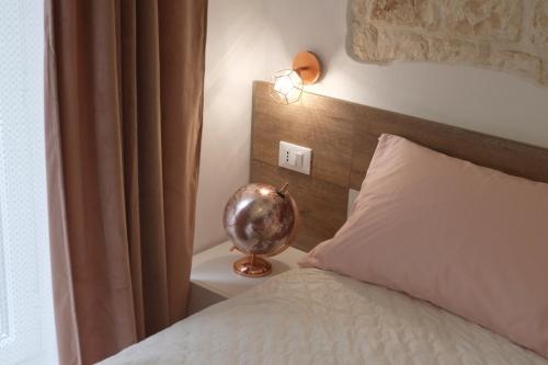a bedroom with a bed and a lamp on a night stand at Via Ricasoli 8 in Ostuni