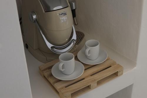 two cups on a wooden tray next to a coffee maker at Via Ricasoli 8 in Ostuni