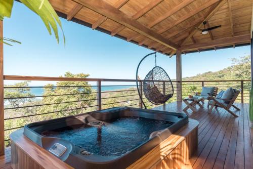 a hot tub on the deck of a house at Vista del Alma Boutique - Adult Only in Santa Teresa Beach
