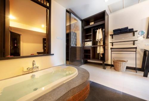 a bathroom with a large tub and a piano at Chada Lanta Beach Resort - SHA Extra Plus in Ko Lanta
