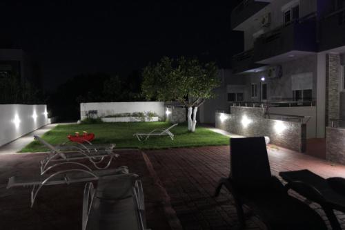 a backyard at night with a table and chairs at Platoni Elite in Ialyssos